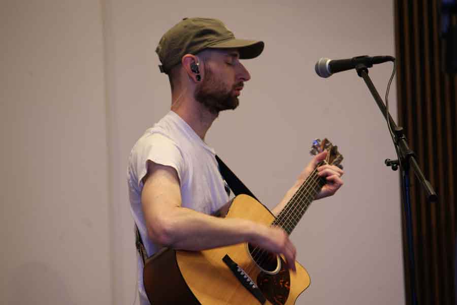 A worship leader playing acoustic guitar