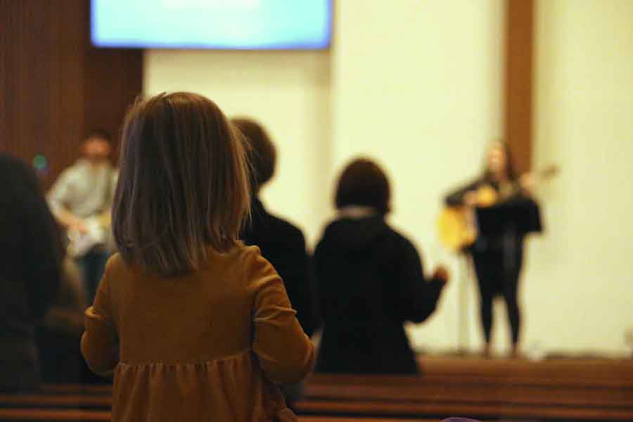 A little girl watching the worship band during a Sunday service