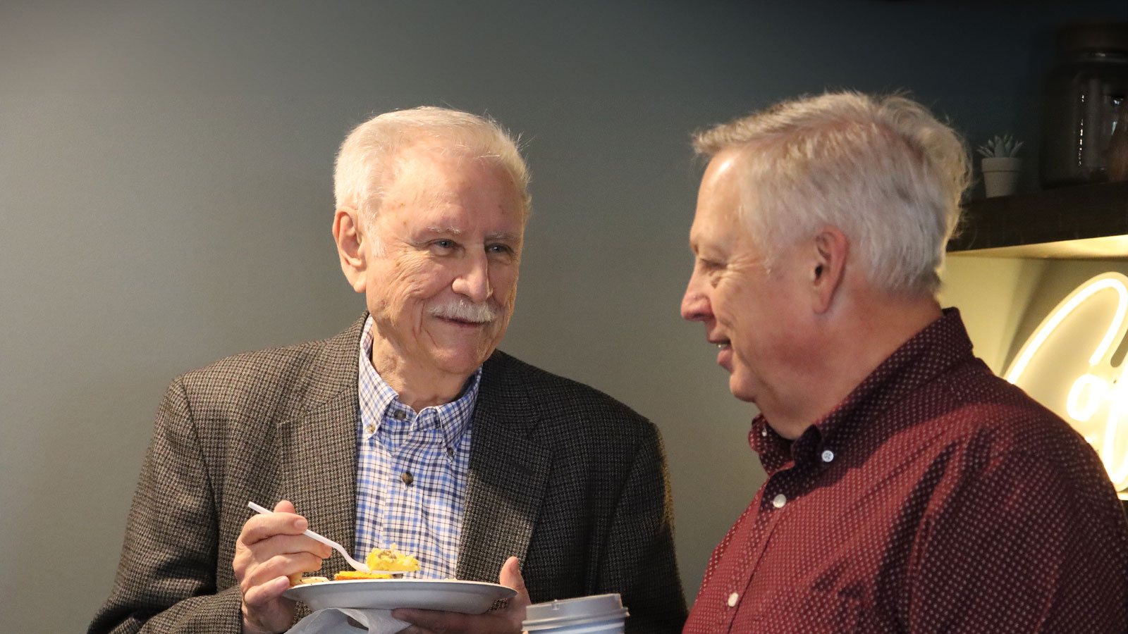 Two men talking over lunch plates at Dwelling House Church