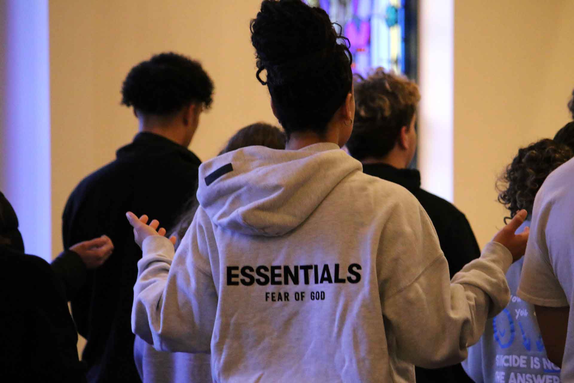 A young adult worshipping with hands raised